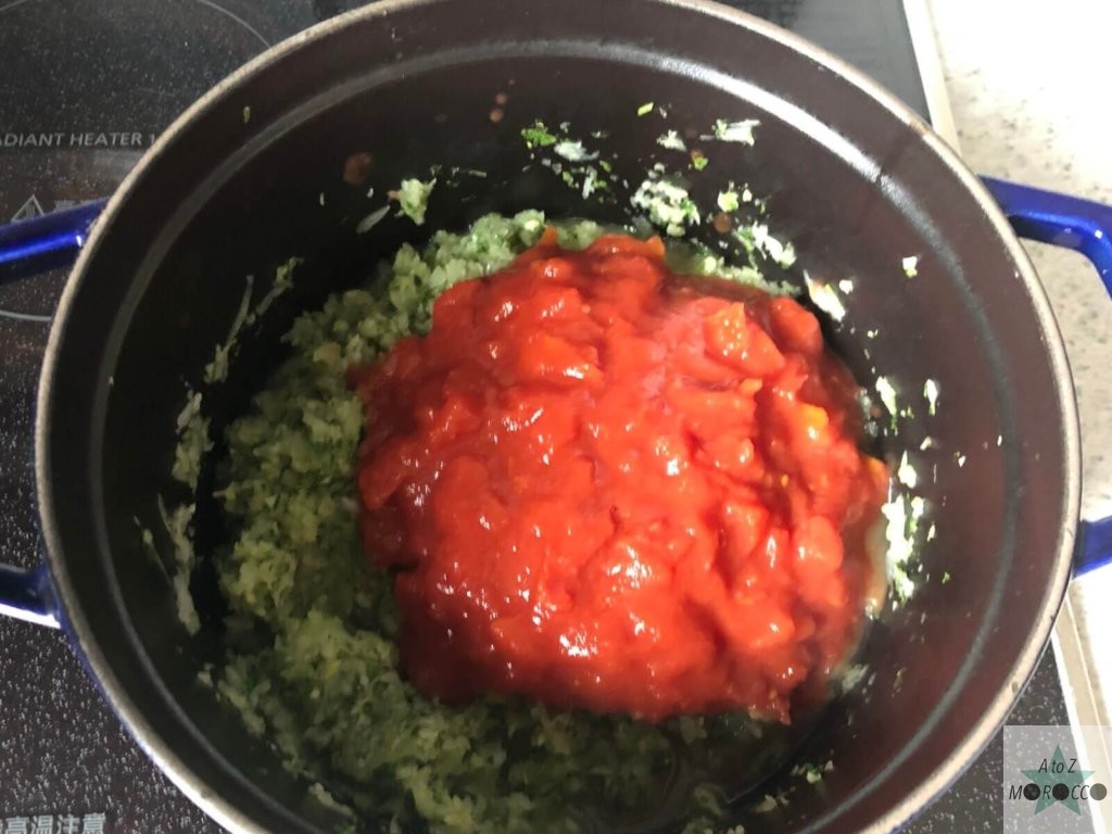 炒めた野菜にトマト缶を入れる